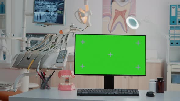 Monitor with Green Screen on Desk in Empty Dentist Office