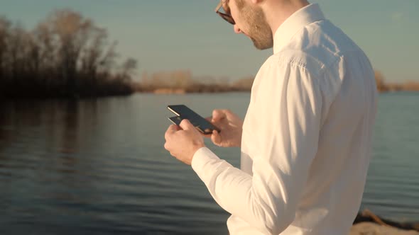 Man Using Mobile Phone And Credit Card For Shopping Online Outdoors. Online Banking With Smartphone.