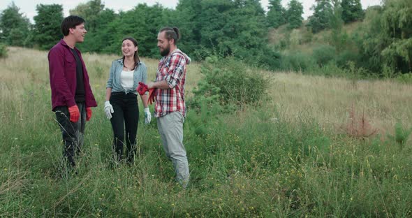 Young Girl and Two Men Discussing Plan and Going to Clean Surrounding Nature