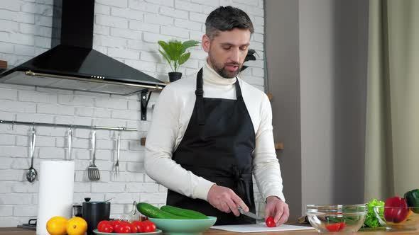 Man chef in apron greets teaches housewife online videocall, sliced fresh cherry
