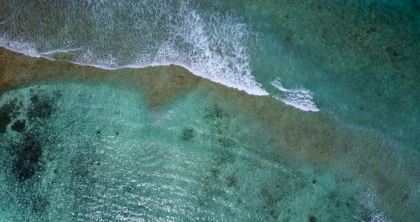 Daytime fly over copy space shot of a paradise sunny white sand beach and blue water background 