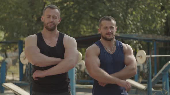 Positive Bodybuilders with Arms Crossed Outdoors