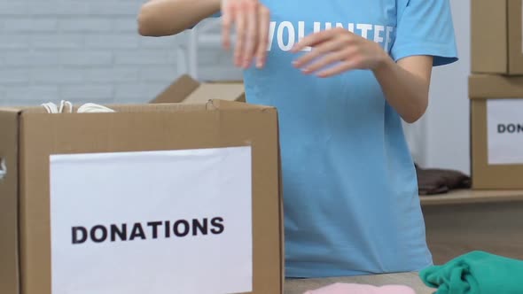 Young Lady Volunteer Packing Belongings in Box for Donations, Poor People Care