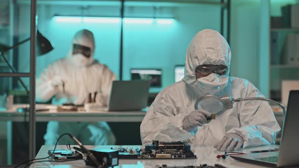 Lab Scientist Examining Chip with Magnifying Glass