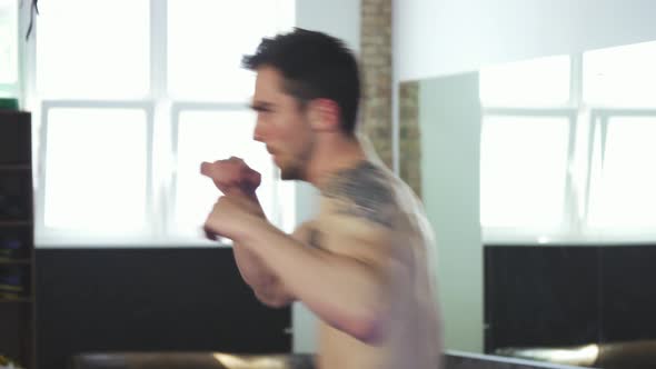 Handsome Muscular Male Boxer Working Out at the Gym Practicing Punches