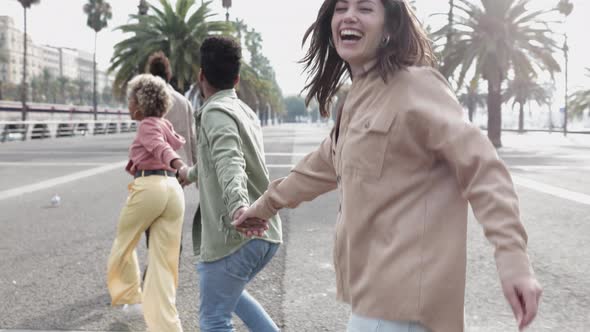 Happy Millennial Young People Running Together in City Street