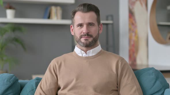 Portrait of Man Looking at Camera at Home