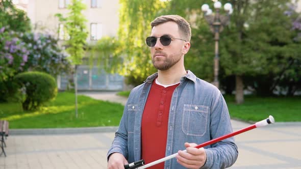 Blind Man Setting Up Walking Cane in Park