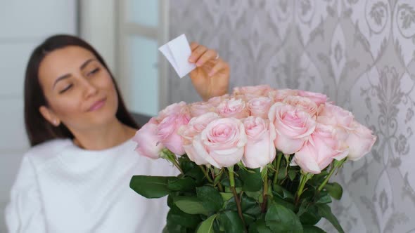 Woman Reads a Card in Flowers