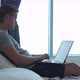 Young Man Sitting on Bed Using His Laptop in the Bedroom at Home - VideoHive Item for Sale