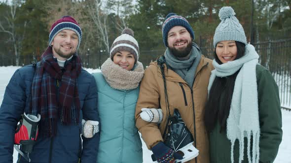 Portrait of Happy Friends Men and Women Holding Ice-skates Standing in Park in Winter Smiling