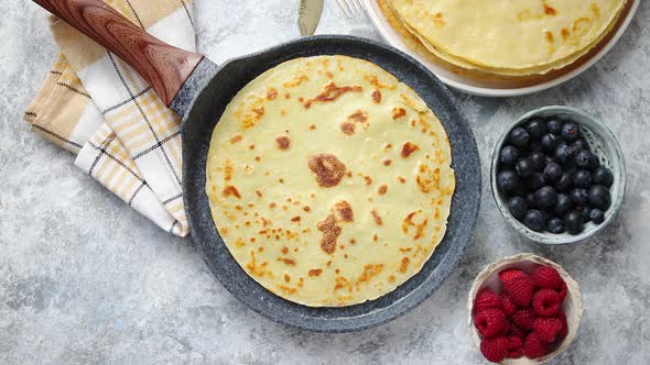 Delicious Pancakes on Stone Frying Pan. Placed on Table with Various Ingredients