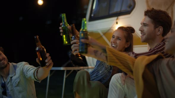 Group of young friends spending time on the camping side at night. Shot with RED helium camera in 8K