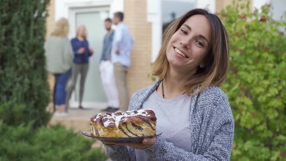 Young Attractive Woman with a Cake Smiling and Looking at Camera