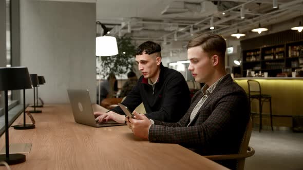 Male managers of the company work behind laptops in the office