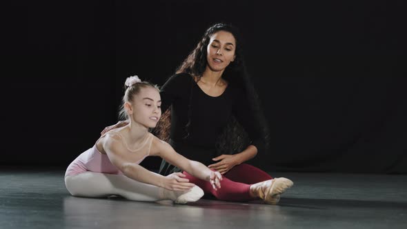 Adult Woman Coach Dancer Teacher Sitting on Floor with Girl Teenager Child Student Acrobat Beginner