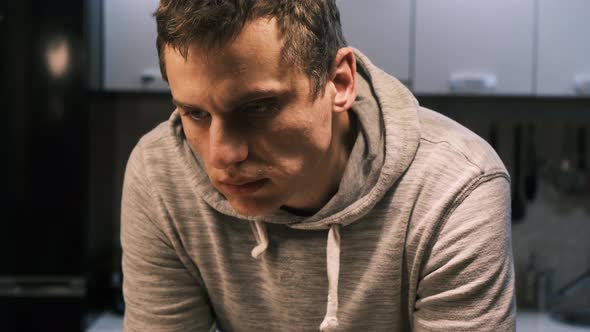 Portrait of a Young Adult Man Chewing Almonds Intently Putting Nuts in His Mouth One By One While