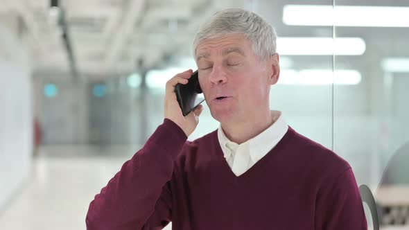 Cheerful Middle Aged Man Talking on Smartphone