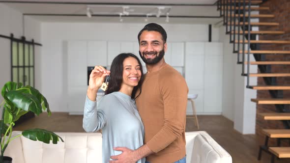 Young Married Couple Smiling Cheerfully and Showing Keys From a New Apartment