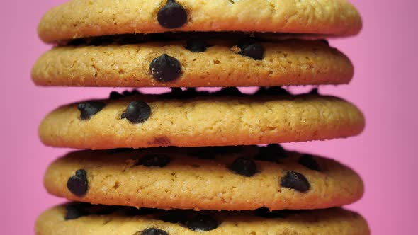 A Stack of Chocolate Chip Cookies Sprouting on a Pink Background