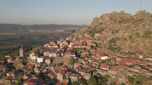 Monsanto village perched on hill, Portugal. Aerial forward tilt up reveal