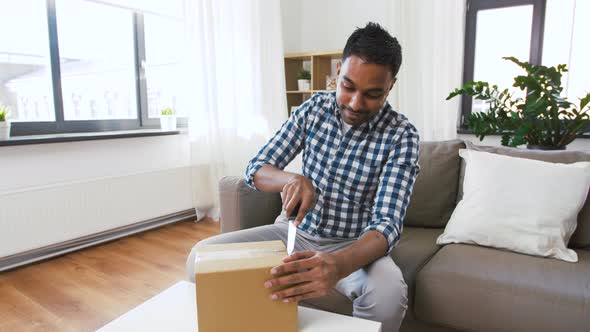 Male Video Blogger Opening Parcel Box at Home