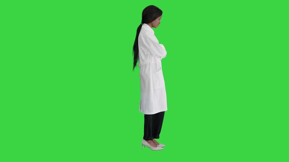 Serious African American Female Doctor Standing with Crossed Hands on a Green Screen Chroma Key