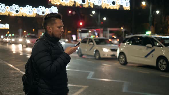 Young Hipster Guy Using Modern Smartphone Outdoors Man Chatting with Friends at Social Networks