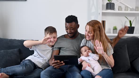 A Happy Multiracial Family of Four with a Tablet