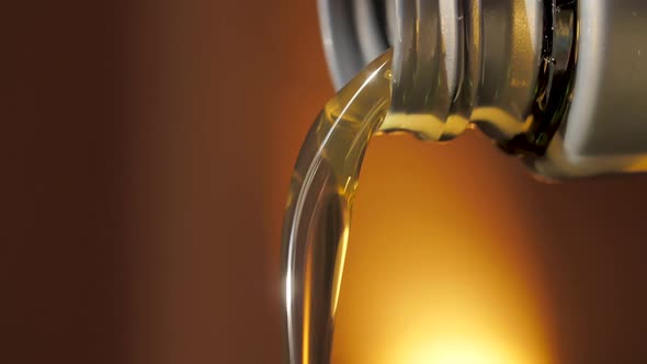 Motor Oil Flows from Neck of Bottle. Liquid Stream Close-up
