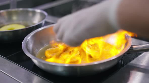 Closeup Pouring Igniting Oil in Cooking Pan with Grilled Shrimps in Slow Motion