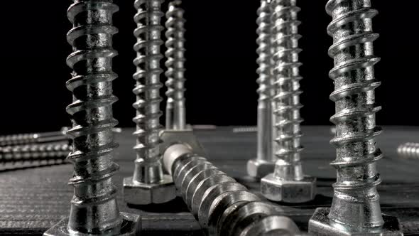 Screws Metal Threaded Bolts Fasteners on Table on Isolated Black Background