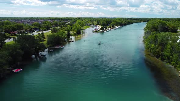 Aerial forward shot above beautiful river,ing luxury boat and forest landscape in background during