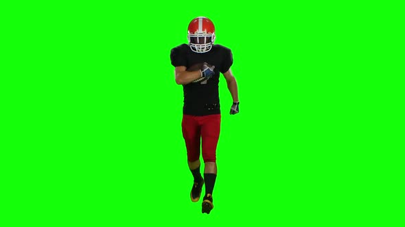 Player Is Running in a Red Helmet with the Ball in His Hands. Front View. Green Screen