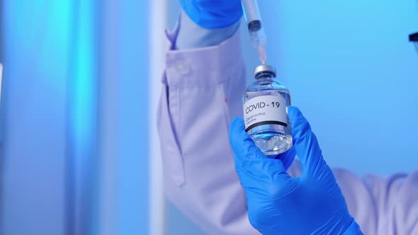 Scientist in PPE suit conducts research on the COVID 19 vaccine at a laboratory.