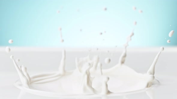 Super Slow Motion Detail Shot of Fresh Milk Crown on Blue Gradient Background at 1000 Fps