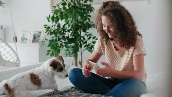 Teenage girl using mobile phone in her bedroom