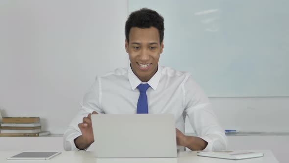 Afro-American Businessman Celebrating Success, Working on Laptop