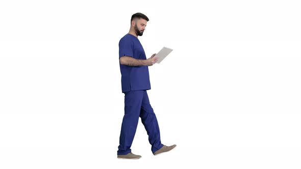 Confident Concentrated Focused Surgeon Using Digital Tablet on White Background