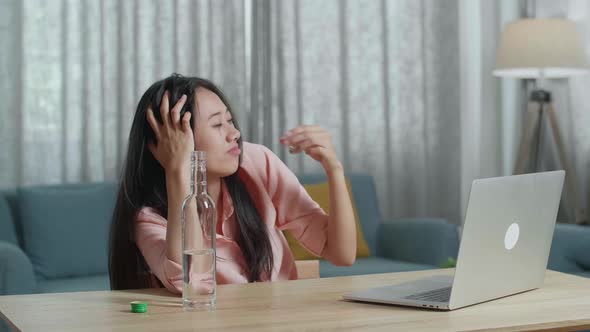 Smiling Asian Woman Drinking Vodka During Having Video Call On A Laptop At The Home