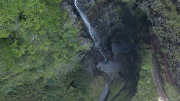Aerial is flying backwards and tilting up towards Waterfall Risco in Madeira