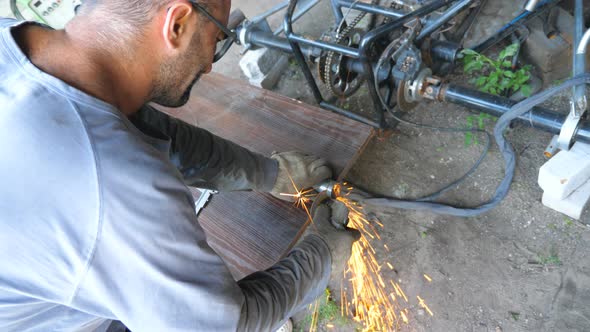 Adult Repairman or Mechanic Grinding Metal Using Circular Saw