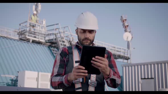 Engineers Using a Tablet on a Cellular Tower