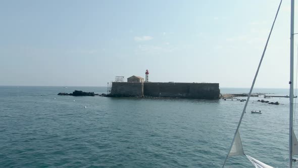 Aerial Approach of a Sea Fort with a Lighthouse 