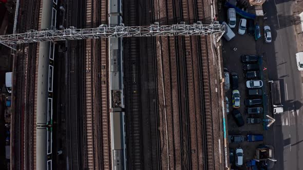 Pan up aerial drone shot of trains entering central London bridge station shard