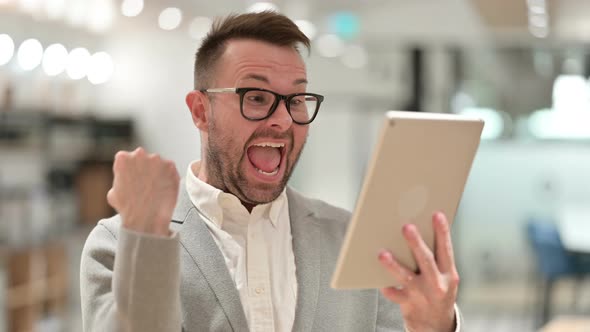 Creative Man Celebrating Success on Tablet 