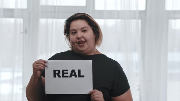 Concept Body Positivity a Fat Charismatic Woman Holds a Sign with the Inscription REAL Looking in