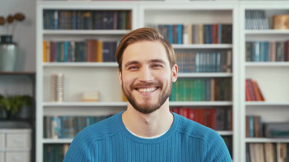 Smiling young man on the background of books in the office