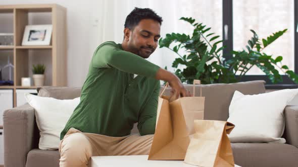 Smiling Indian Man Unpacking Takeaway Food at Home