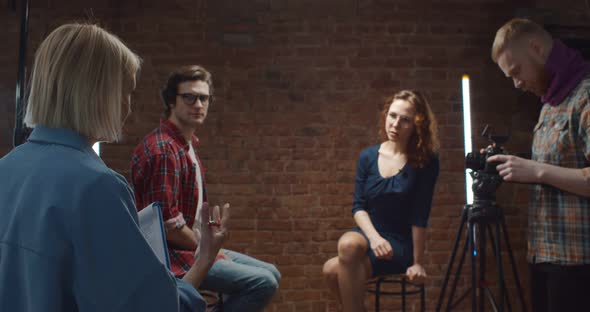 Woman Director Talking To Host and Guest in Studio Before Filming Interview